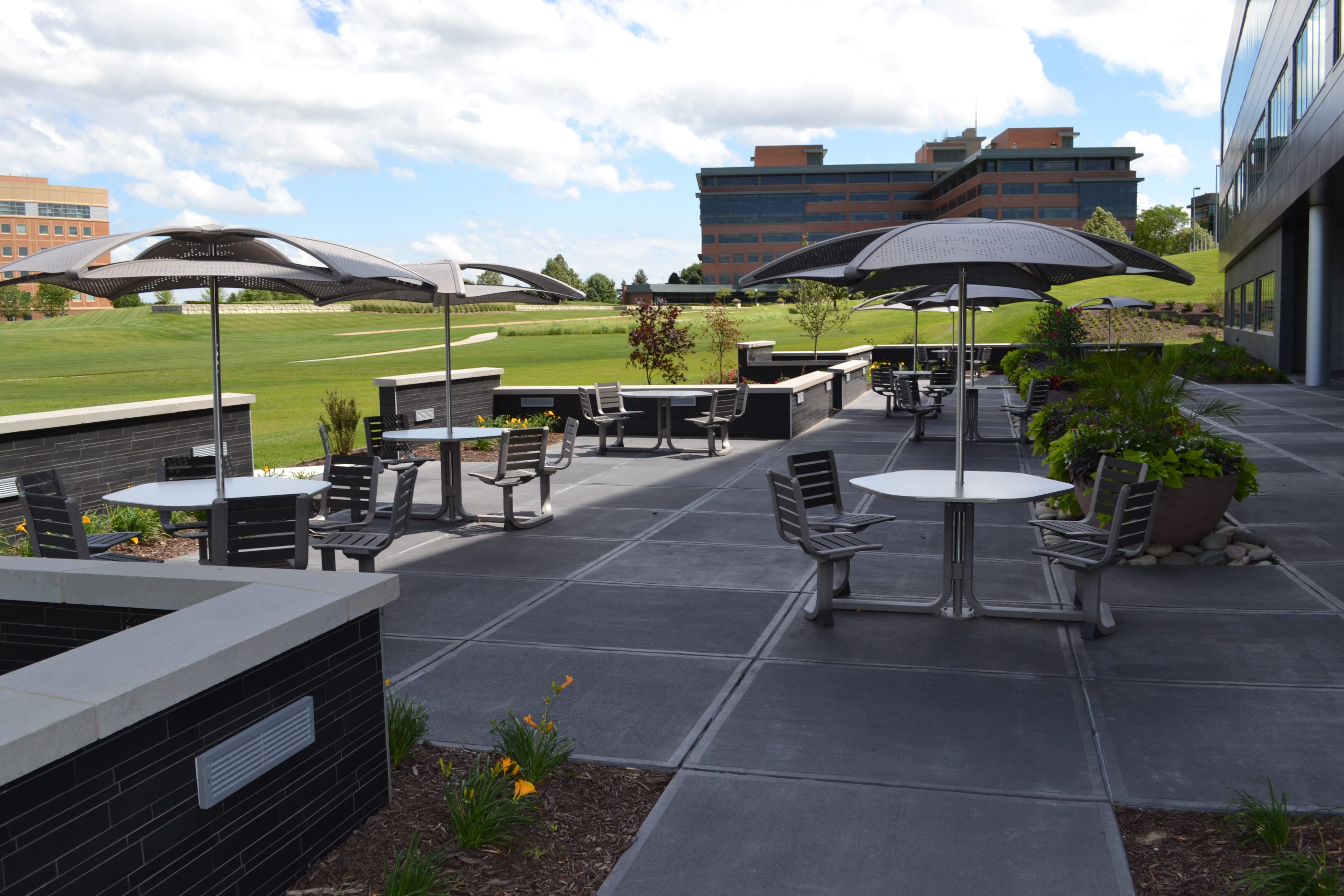 Norstone Ebony Lynia Natural Stone Interlocking Tile on a garden wall in the seating area of a corporate ourdoor space